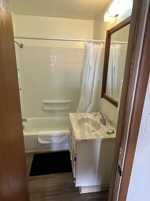 Bañera con ducha, toallas, jabón, shampoo