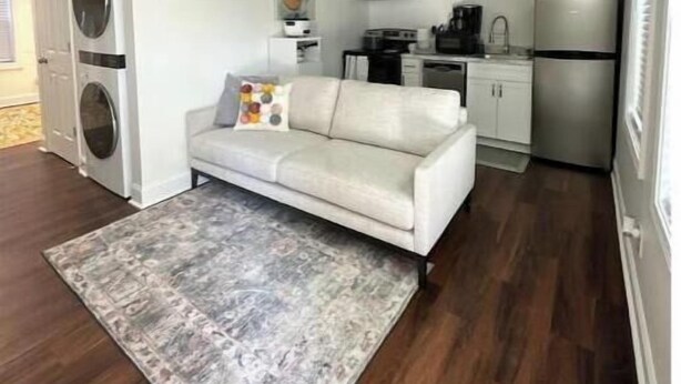 Ein kompakter Wohnbereich mit Sofa, Waschmaschine, Kaffeemaschine und Kühlschrank.