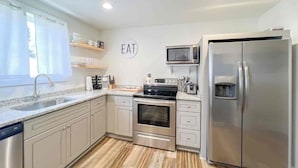 A modern kitchen with stainless steel appliances, a microwave, and a refrigerator.