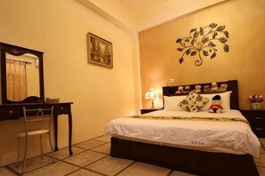 A bedroom with a bed, a desk, a chair, a mirror, and a wall decoration. - Hualian Dawan (Hualien)