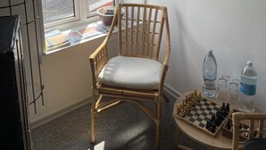 A room with a window, a chair, a chessboard, and a painting on the wall. - Apartments in the heart of Hojer (Højer)