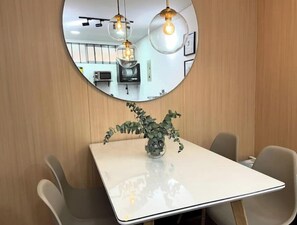 Relax in a serene space with a round mirror, a stylish table, and comfortable seating.