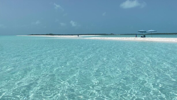 Una playa con agua turquesa cristalina y una orilla arenosa.