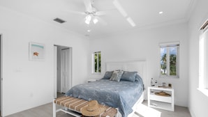 A modern bedroom with a bed, a bench, a nightstand, and a window. - Snowbird Paradise - New Vacation Home in Key Largo (Key Largo)