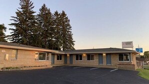 A motel with a simple, single-story structure, a parking lot, and a signboard. - Lakeside Motel (Ashland)