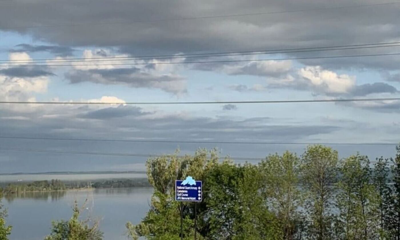 A signboard with a mountain and a lake in the background.