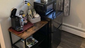 A compact kitchenette with a coffee maker, microwave, and a small refrigerator. - Lakeside Motel (Ashland)