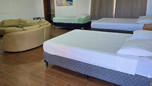 A hotel room with two beds, a sofa, and a wooden floor. - Private Beach Villa w/ Pool • 5 Bedrooms • Sleeps 14 (El Velero)