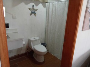 A small bathroom with a toilet, a sink, and a shower curtain. - Private Beach Villa w/ Pool • 5 Bedrooms • Sleeps 14 (El Velero)