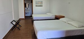 A hotel room with two beds, a wooden nightstand, and a painting on the wall. - Private Beach Villa w/ Pool • 5 Bedrooms • Sleeps 14 (El Velero)