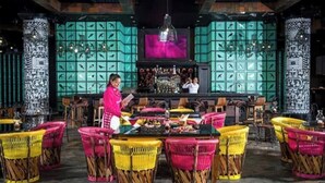 Una zona de bar con sillas de mimbre y un barman.