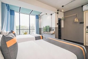 A hotel room with two beds, a television on a stand, a desk with a chair, and a window with curtains. - Xihu Yingxiu Xinsu Guesthouse (Huizhou)