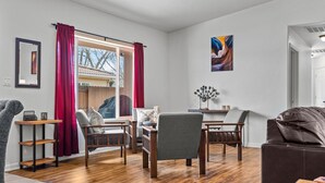 A modern living room with a wooden floor, a dining table, and two sofas. - Cottonwoods 477 (Moab)