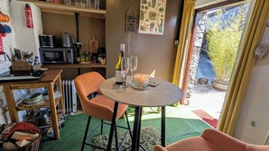 Una habitación acogedora con una mesa de comedor, sillas, una vela y una botella de vino.