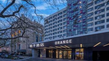 A hotel entrance with a modern facade, a visible staircase, and a sign indicating the hotel name.