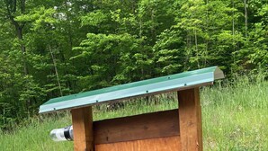 A portable electric vehicle charging station with a JuiceBox charging unit, connected to a power outlet and a cable. - Cozy private Cabin Farm stay with WiFi in Irvine (Irvine)
