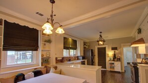Una cocina moderna con armarios blancos, una isla central y un comedor con mesa y sillas.