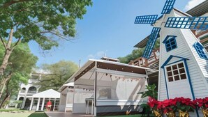 A traditional windmill with a white and blue exterior, a covered outdoor seating area, and a well-maintained lawn. - Inn Rose (Taoyuan)