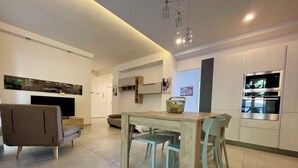 Una cocina moderna con una mesa de comedor, sillas y un microondas.