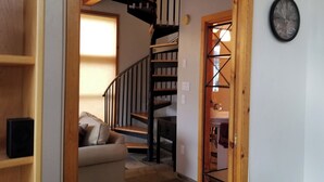 A staircase leading to a second floor, a sofa in the foreground, and a clock on the wall. - Charming country house with WiFi in Nutrioso (Nutrioso)