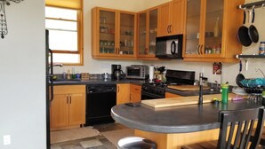 A compact kitchen with wooden cabinets, a microwave, a toaster, and a sink. - Charming country house with WiFi in Nutrioso (Nutrioso)