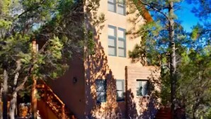 A two-story house with a sloped roof, surrounded by trees. - Charming country house with WiFi in Nutrioso (Nutrioso)