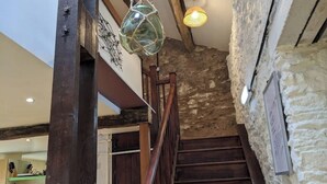 A staircase with wooden steps and a stone wall, leading to a room with a wooden ceiling and a hanging light fixture. - Glamping Barns & Bothy, in Caldbeck, Lake District (Caldbeck)