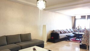 Ein modernes Wohnzimmer mit einem grauen Sofa, einem weißen Couchtisch und einer Chandelier.