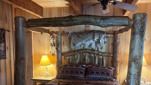 Un lit en bois rustique au design original, agrémenté de motifs animaliers sur la tête de lit et le pied de lit.