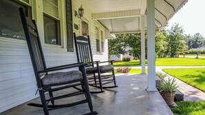 A porch with two rocking chairs and a potted plant. - Miss Audrey’s House is a charming cottage in the heart of historic Richmond Hill (Richmond Hill)