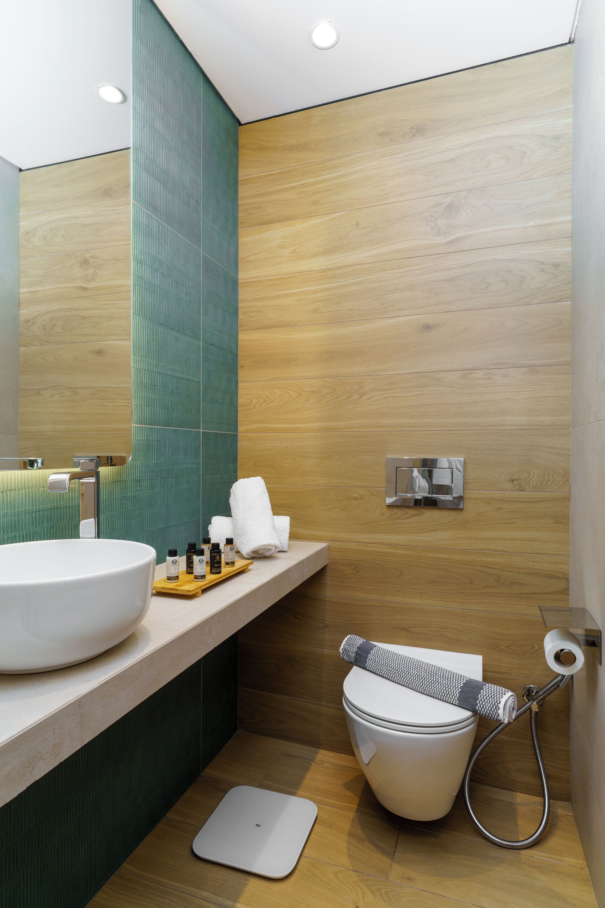 A modern bathroom with a large sink, a toilet, and a shower.
