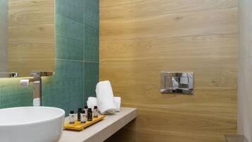 A modern bathroom with a large sink, a toilet, and a shower.