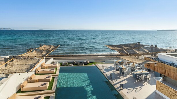 A rooftop pool area with seating and tables, overlooking the sea. - NOIMA Casa Unico (Agistri)