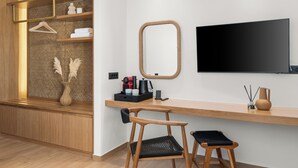A modern room with a wooden desk, two chairs, a TV, and a mirror. - NOIMA Casa Unico (Agistri)