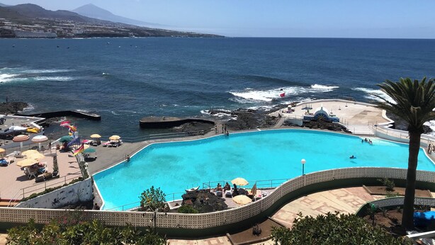 A swimming pool with a view of the ocean and a mountain in the background. - Apartamento Junto al Mar, Wi-fi Gratis. Hasta 3 Personas (Punta del Hidalgo)