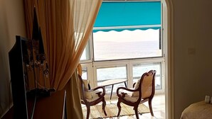 A room with a large window, a wooden chair, a small table, and a bed. - Apartamento Junto al Mar, Wi-fi Gratis. Hasta 3 Personas (Punta del Hidalgo)