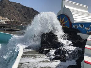 Une côte rocheuse où les vagues s’écrasent contre les rochers.