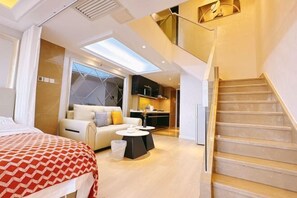 A modern hotel room with a bed, a sofa, a dining table, and a staircase. - Yijia Apartment (Beijing Workers' Stadium) (Beijing)