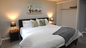 A bedroom with a bed, bedside lamps, a painting, and a closet. - Large Family Retreat in Quiet Denver Spot (Denver)