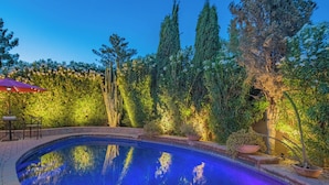 A swimming pool surrounded by lush greenery and a patio area with a table and chairs. - Scottsdale Treasure: Private Pool and Tranquil Yard Retreat! (Scottsdale)