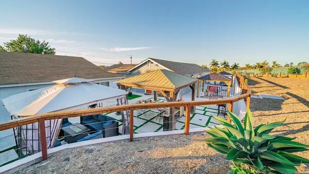 A residential area with multiple houses, a wooden deck, and a fenced yard. - Melrose Pet-Friendly 3BR. Feel like royalty (Vista)