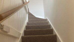 Eine Treppe mit Teppichstufen und einem Holnänder.