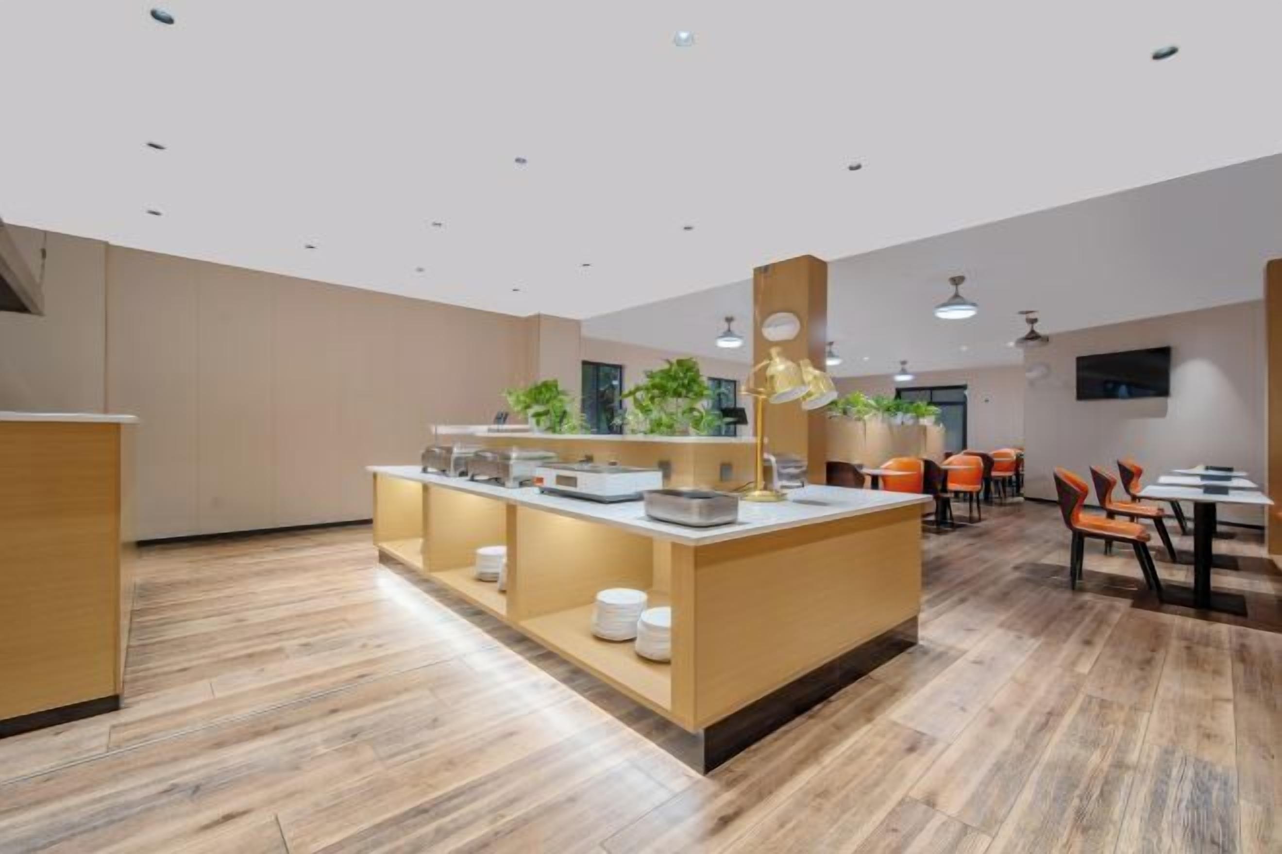 Ein modernes Interieur mit einer zentralen Theke, einer Sitzgruppe und Holzdielen.
