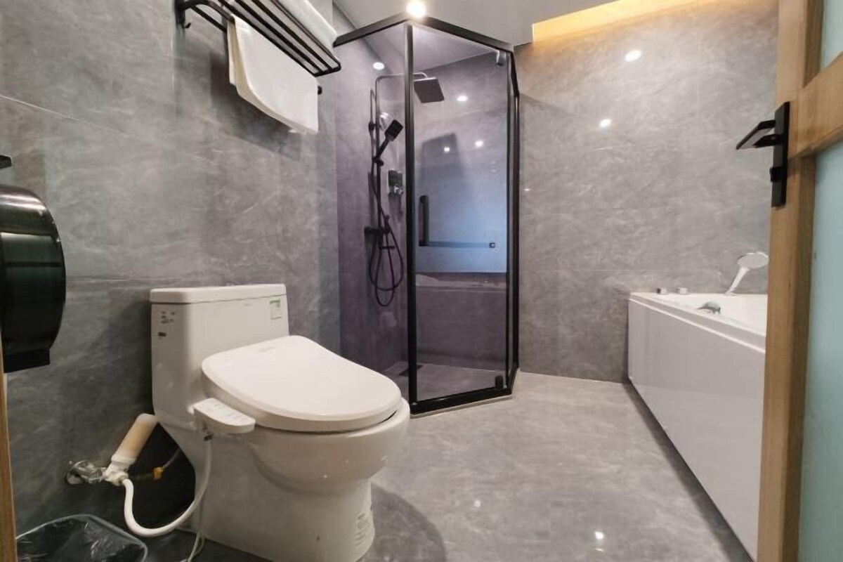 Un baño moderno con inodoro, cabina de ducha y bañera.