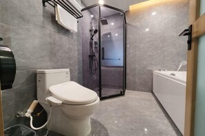 Un baño moderno con inodoro, cabina de ducha y bañera.