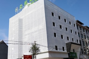 A multi-story building with a modern architectural design, featuring a series of windows and a flat facade.