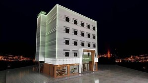 A modern hotel with a multi-story structure, a prominent entrance, and a well-lit facade.