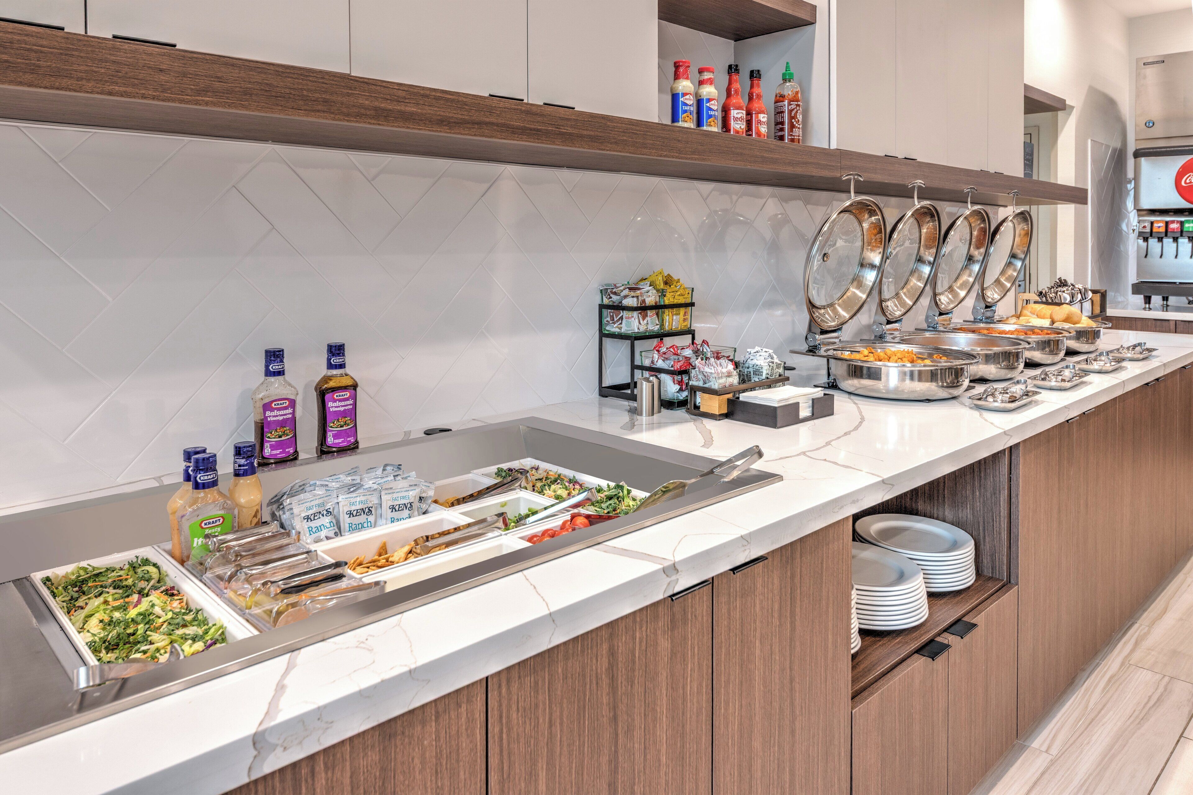 Disposição de buffet com diversos alimentos e acompanhamentos.