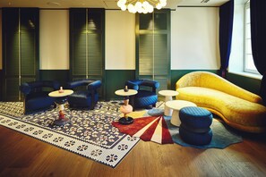 A room with a yellow sofa, blue armchairs, a patterned rug, and a wooden floor. - Hotel Indigo Nagasaki Glover Street by IHG (Nagasaki)