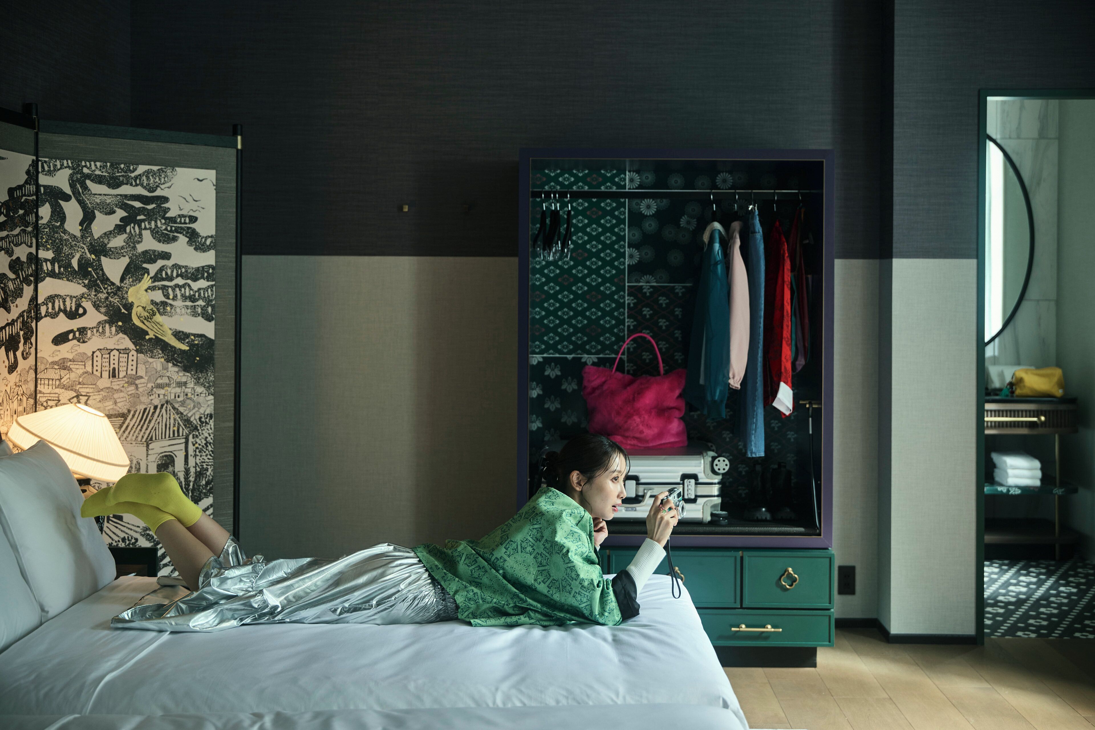 Una habitación de hotel con cama, armario y espejo.